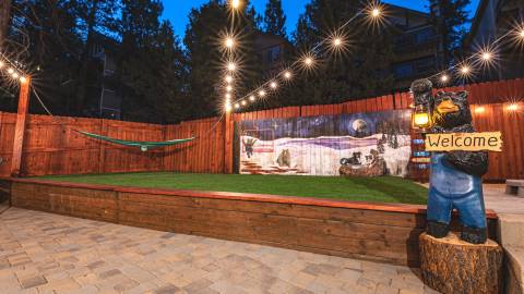 Una foto de Winterland Cabins: hay una estatua de un oso que sostiene un cartel de «Bienvenidos».