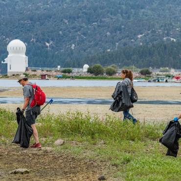 Voluntarios recogen basura de la orilla del lago Big Bear durante una campaña de limpieza de Care For Big Bear.