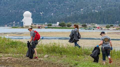 Voluntarios recogen basura de la orilla del lago Big Bear durante una campaña de limpieza de Care For Big Bear.