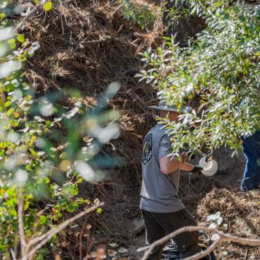 Voluntarios retiran la basura del lecho de un arroyo durante una limpieza de Care For Big Bear.