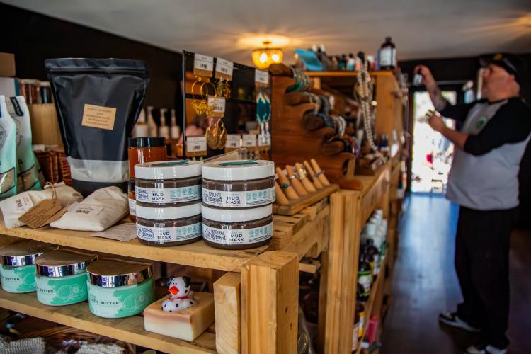 Una foto del interior de Rewind Collective: hay estanterías con diversos productos de bienestar, como mascarillas de barro y mantecas corporales.
