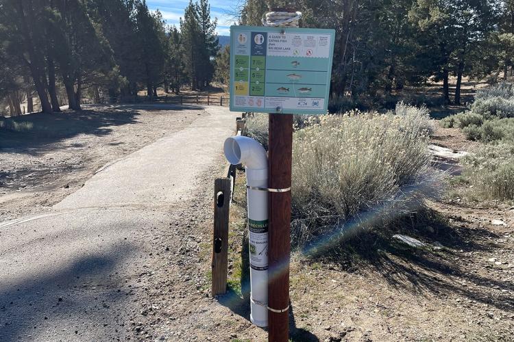 Un punto de recogida de hilos de pesca en Big Bear Lake; el punto se encuentra en un sendero rodeado de árboles e incluye una guía sobre cómo comer pescado.