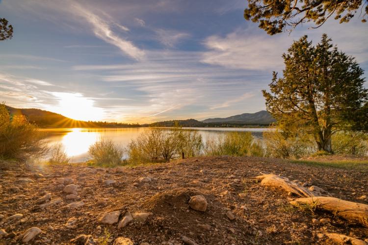 Un amanecer dorado a orillas de Juniper Point, en el lago Big Bear (California); las aguas del lago reflejan la luz del sol.