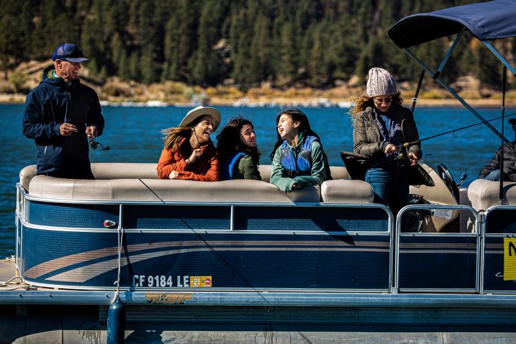 Una familia en pontón disfruta de un día de pesca en el lago Big Bear.