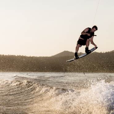 Un wakeboarder coge aire en una ola de Big Bear Lake