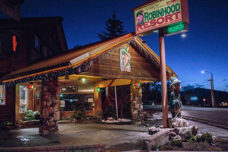 Una foto de la entrada del edificio Robinhood Resort durante la noche: luces festivas cuelgan del techo.