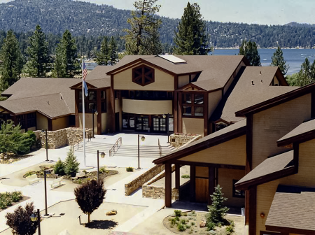 Una imagen aérea del ayuntamiento de Big Bear Lake. Al fondo se divisan el lago azul y el bosque verde.