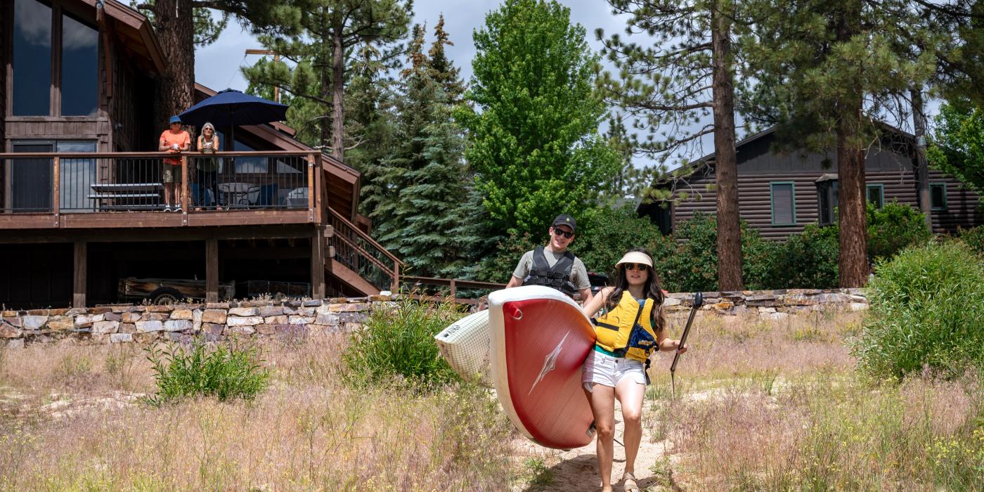 Niños con tablas de paddle en la orilla del lago