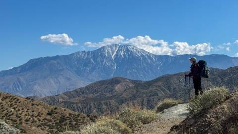 Foto de un excursionista con vistas al valle de Big Bear, con las montañas nevadas visibles a lo lejos.