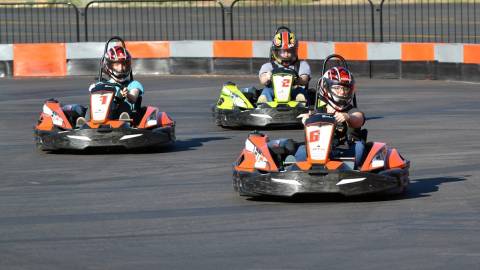 Tres karts en Big Bear Snow Play, situados a distintas distancias y dirigiéndose hacia el espectador; las personas que los conducen llevan casco.