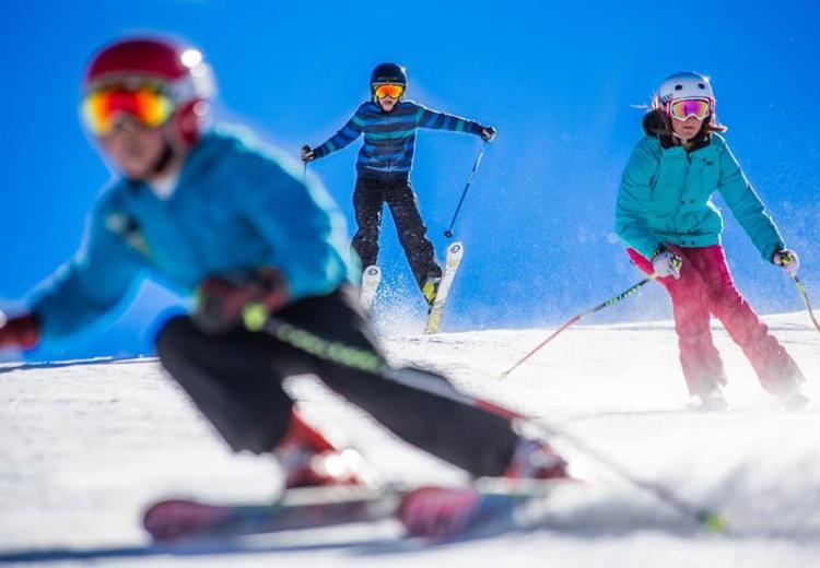 Los niños descienden por las pistas de esquí invernal de Big Bear