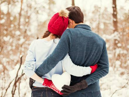 una pareja sostiene una bola de nieve de corazón en Big Bear, CA