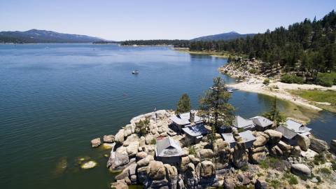 Una casa de estilo chino se asienta sobre una isla rocosa en Big Bear Lake. Es un día soleado con cielos azules.