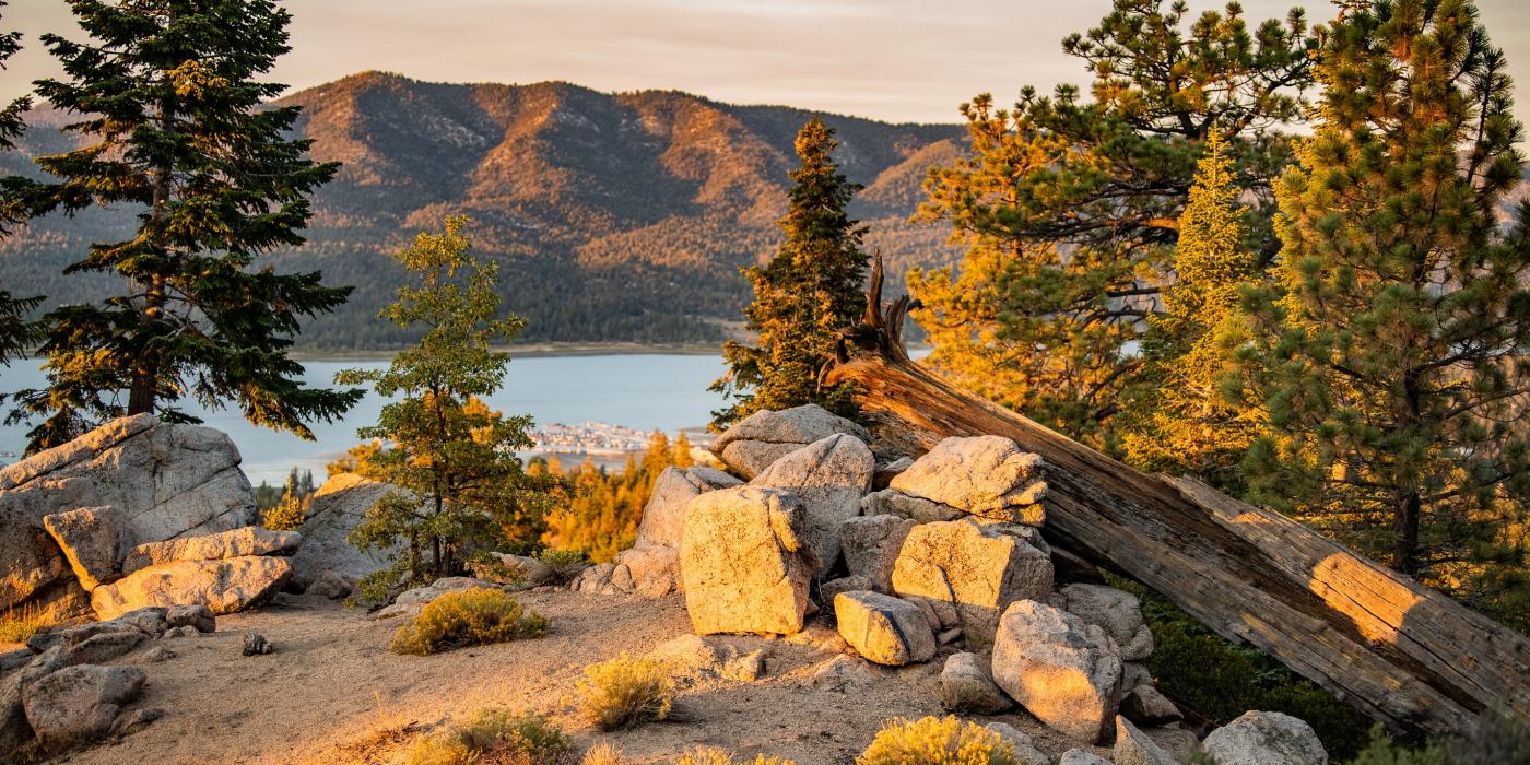 Una vista de Big Bear Lake a través de los árboles desde la ruta de senderismo Castle Rock en la temporada de otoño. Es la puesta de sol.