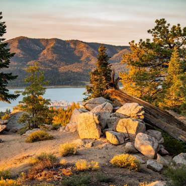 Una vista de Big Bear Lake a través de los árboles desde la ruta de senderismo Castle Rock en la temporada de otoño. Es la puesta de sol.