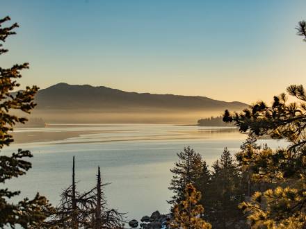 Una foto tomada durante una hora dorada en Big Bear Lake, la niebla y el agua del lago reflejando suavemente la luz dorada.