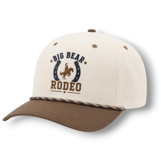 Un sombrero blanco y marrón vendido durante el rodeo de Big Bear Lake; en la parte delantera tiene una herradura que rodea a un vaquero y su caballo.