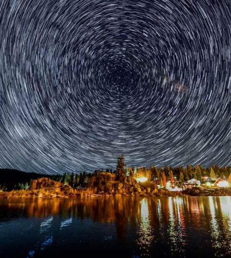 Un timelapse de estrellas en círculo en el cielo nocturno sobre Boulder Bay en Big Bear Lake, CA.