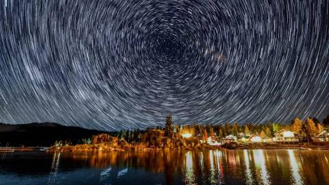 Un timelapse de estrellas en círculo en el cielo nocturno sobre Boulder Bay en Big Bear Lake, CA.