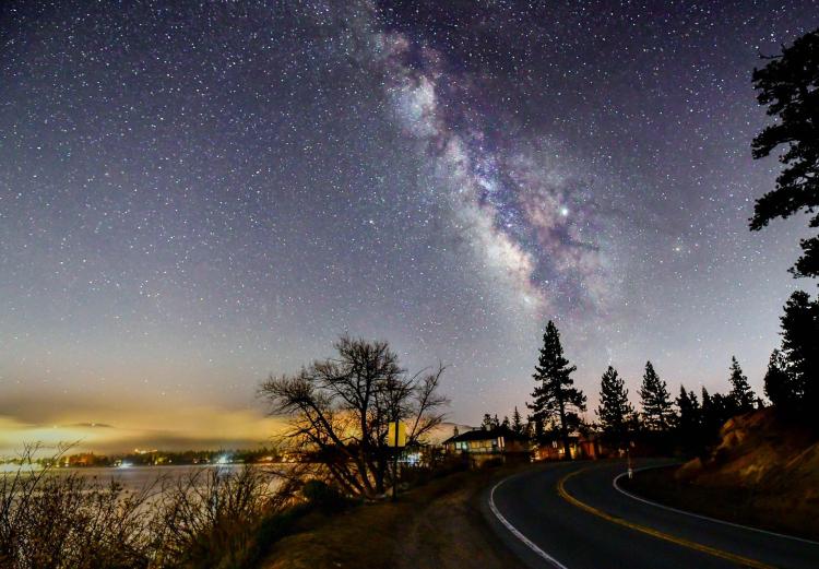 A photo of Big Bear's beautiful night sky, the bright stars and a galaxy are visible.