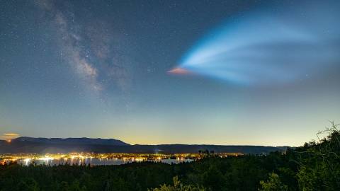 La Vía Láctea, que se ve arriba, como un cometa que deja una estela brillante al atravesar el oscuro cielo nocturno sobre el lago Big Bear.