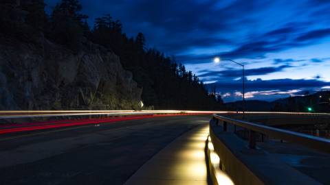 Una carretera de montaña de noche, iluminada por las luces de la calle y los faros de los coches, en Big Bear Lake, California.