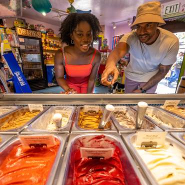 Una pareja mira a través de un cristal una selección de coloridos sabores de helado en una tienda de dulces en The Village at Big Bear Lake, CA.