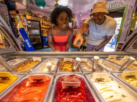 Una pareja mira a través de un cristal una selección de coloridos sabores de helado en una tienda de dulces en The Village at Big Bear Lake, CA.