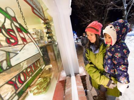 Una madre sostiene a su hija mientras disfruta de las compras en The Village at Big Bear Lake
