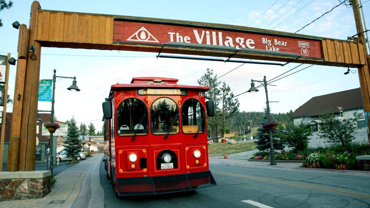 El Mountain Trolley pasando por debajo de "The Village Sign" de Big Bear
