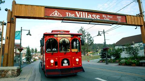 El Mountain Trolley pasando por debajo de "The Village Sign" de Big Bear