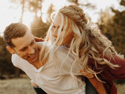 Un hombre carga a su prometida a la espalda durante una juguetona sesión de fotos de compromiso en Big Bear Lake, California.