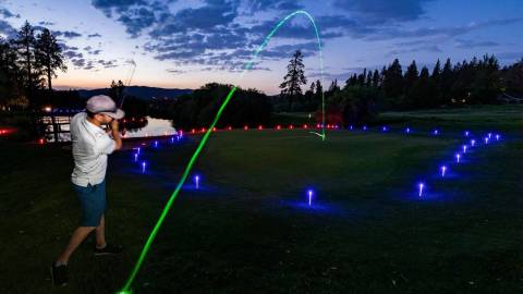 Una foto del Glow Golf de Bear Mountain Resort, la bola verde de colores brillantes volando por el aire.