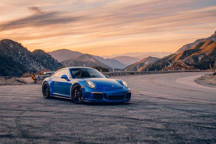 Un Porsche azul junto a una sinuosa carretera de montaña. Promocionando el evento Porsche timeline en Big Bear Lake.