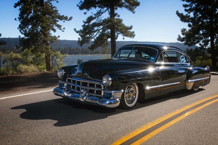 Coche antiguo circulando cerca del lago