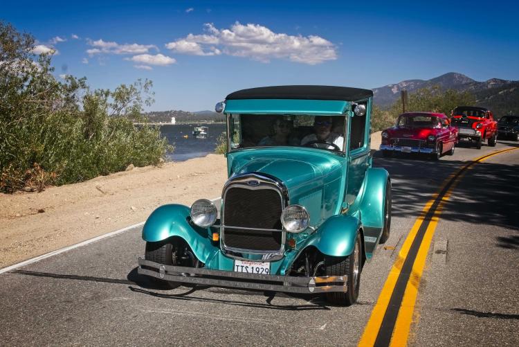 Un coche antiguo azul circula cerca del agua del lago Big Bear durante la carrera Big Bear Fun Run.