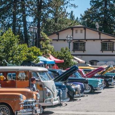 Coches antiguos, relucientes y de colores variados, llenan el aparcamiento del evento «Cool Run in the Mountains». Se han levantado los capós para que los espectadores puedan verlos.
