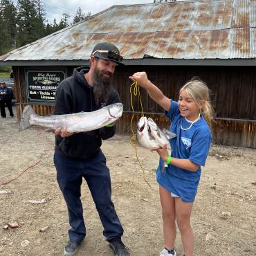 Un padre y su hija sostienen la trucha que pescaron durante el Torneo de Truchas Fishin' For $50K 2023 en Big Bear Lake.