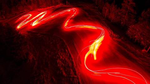 Un chorro de antorchas encendidas ilumina una pista de esquí durante un desfile de Año Nuevo en Big Bear, California. Toma de larga exposición.