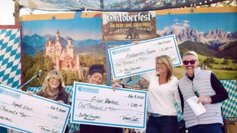 Three winners of the Big Bear scarecrow competition holding up their signed checks from Visit Big Bear