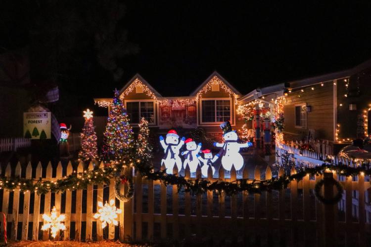Una foto del Festival de las Luces, con muñecos de nieve, árboles decorados, luces y copos de nieve.