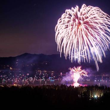 Un espectáculo de fuegos artificiales durante el 4 de julio por encima de Big Bear Lake, las corrientes blancas de chispas y brasas volando por el aire.