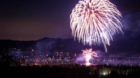 Un espectáculo de fuegos artificiales durante el 4 de julio por encima de Big Bear Lake, las corrientes blancas de chispas y brasas volando por el aire.
