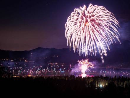 Un espectáculo de fuegos artificiales durante el 4 de julio por encima de Big Bear Lake, las corrientes blancas de chispas y brasas volando por el aire.