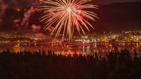 Fuegos artificiales rojos y dorados explotan sobre Big Bear Lake durante el espectáculo de fuegos artificiales del fin de semana del Memorial Day.