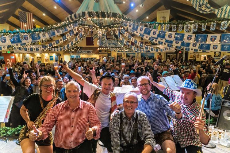 Un numeroso grupo de asistentes al Oktoberfest saluda a la cámara en el Oktoberfest de Big Bear Lake.