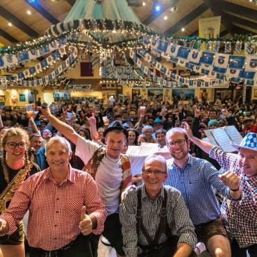 Un numeroso grupo de asistentes al Oktoberfest saluda a la cámara en el Oktoberfest de Big Bear Lake.