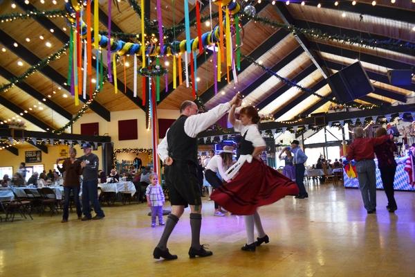 Un hombre y una mujer vestidos con trajes tradicionales de Maifest bailando en Wyatt's