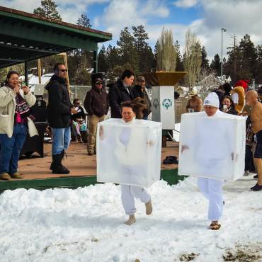 Asistentes disfrazados de cubitos de hielo corren por la nieve en la zambullida polar de Big Bear