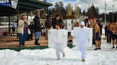 Asistentes disfrazados de cubitos de hielo corren por la nieve en la zambullida polar de Big Bear